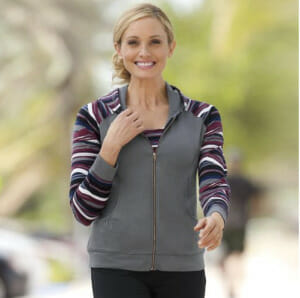 Woman in gray and multi-color stripe zip-up hoodie and black pants