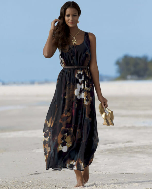 This season it's all about the thin belts. Woman in black floral maxi dress with brown belt