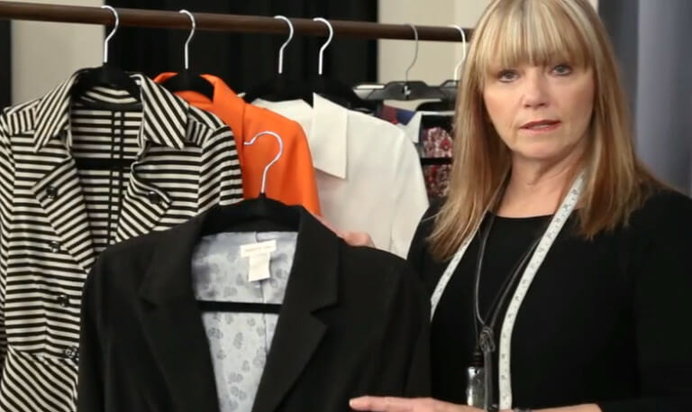 Fashion designer holding up black jacket