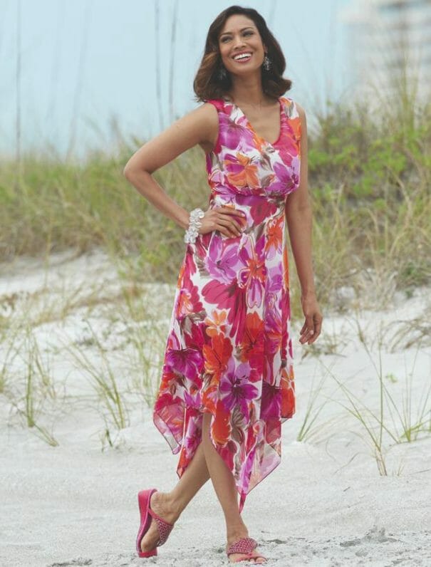Woman in sheer floral dress with hankie hem and pink sandals