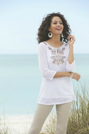 Woman in white embroidered collar top and beige pants