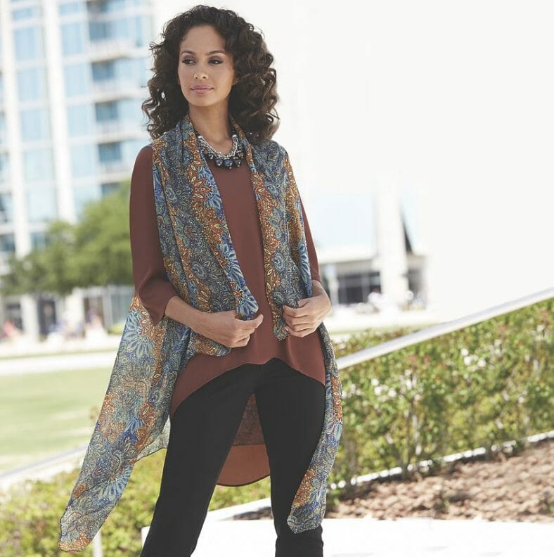 woman in black pants, brown tunic and multi-color vest scarf