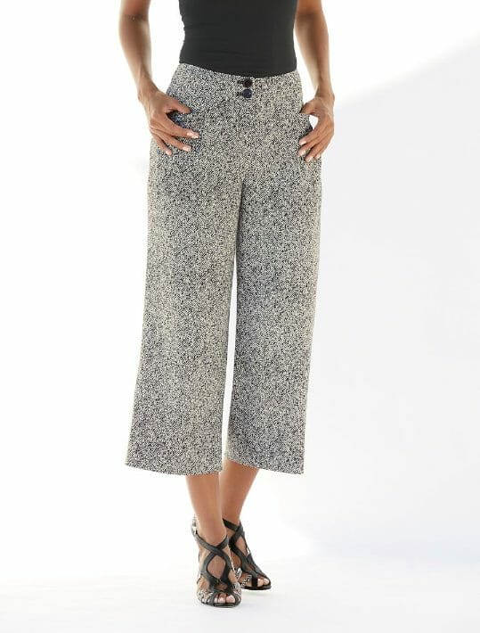 Woman in tweed crop trousers, black shirt and black heels