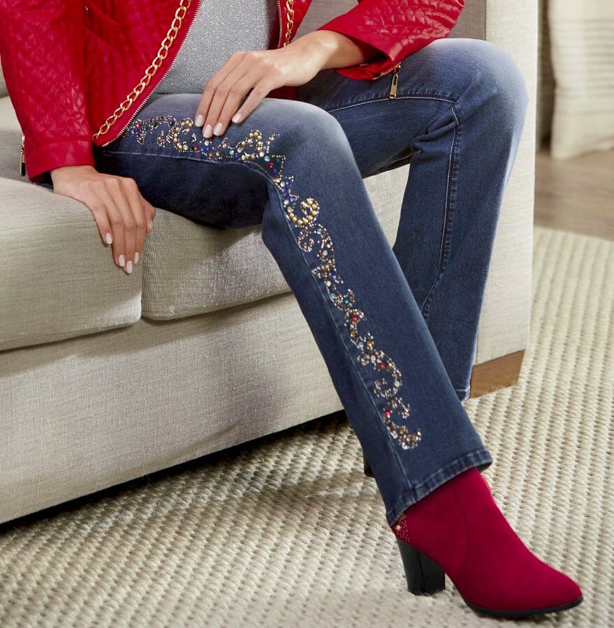 Woman in red booties, embellished jeans, red quilted chain jacket over silver top