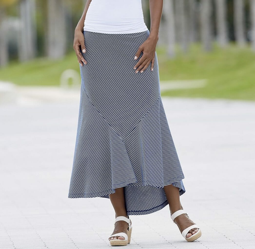 Woman in white wedges, blue and white striped skirt with fishtail hem and white top