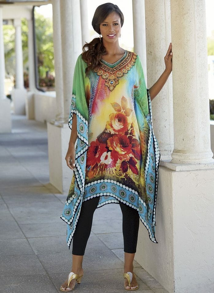 Woman in gold sandals, black crop leggings and rosette emerald caftan