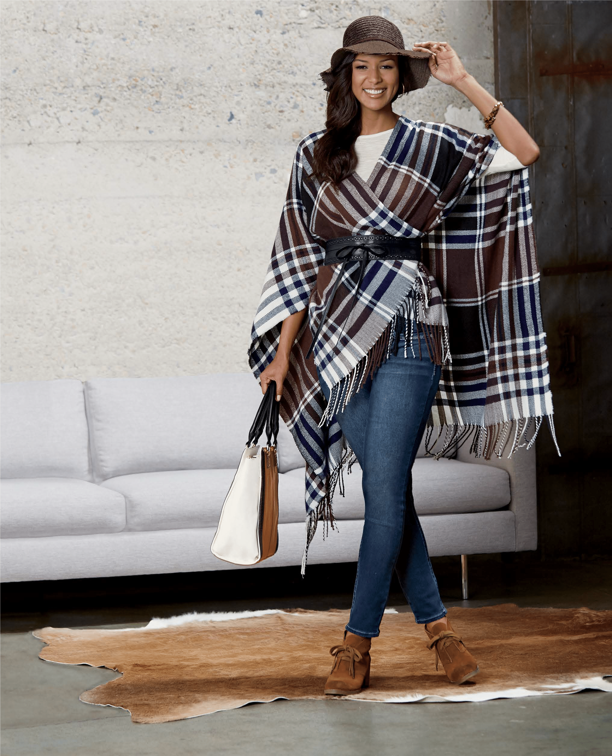 Woman in jeans, white top and plaid scarf poncho with belt