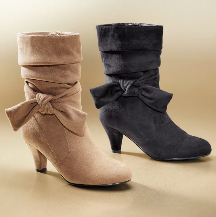 Two stylish ankle boots, one beige and one black, both featuring a folded cuff and a bow detail, set against a golden background.