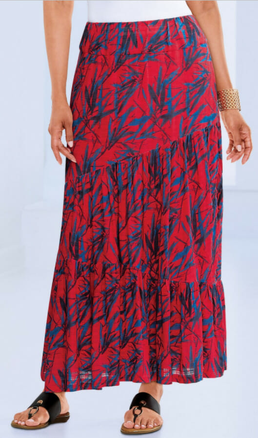 Flowy red maxi skirt with a layered design and a floral pattern, paired with black sandals.