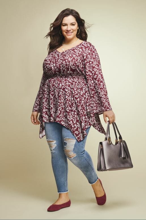 plus size model wearing a sharkbite top and ripped jeans