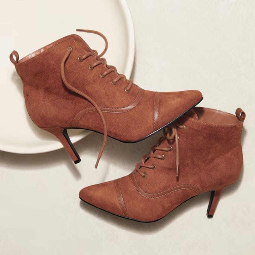 Brown suede ankle boots with a pointed toe and stiletto heel, featuring lace-up detailing and a sleek design.