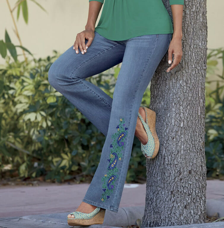Woman in green top, embroidered jeans and turquoise wedges