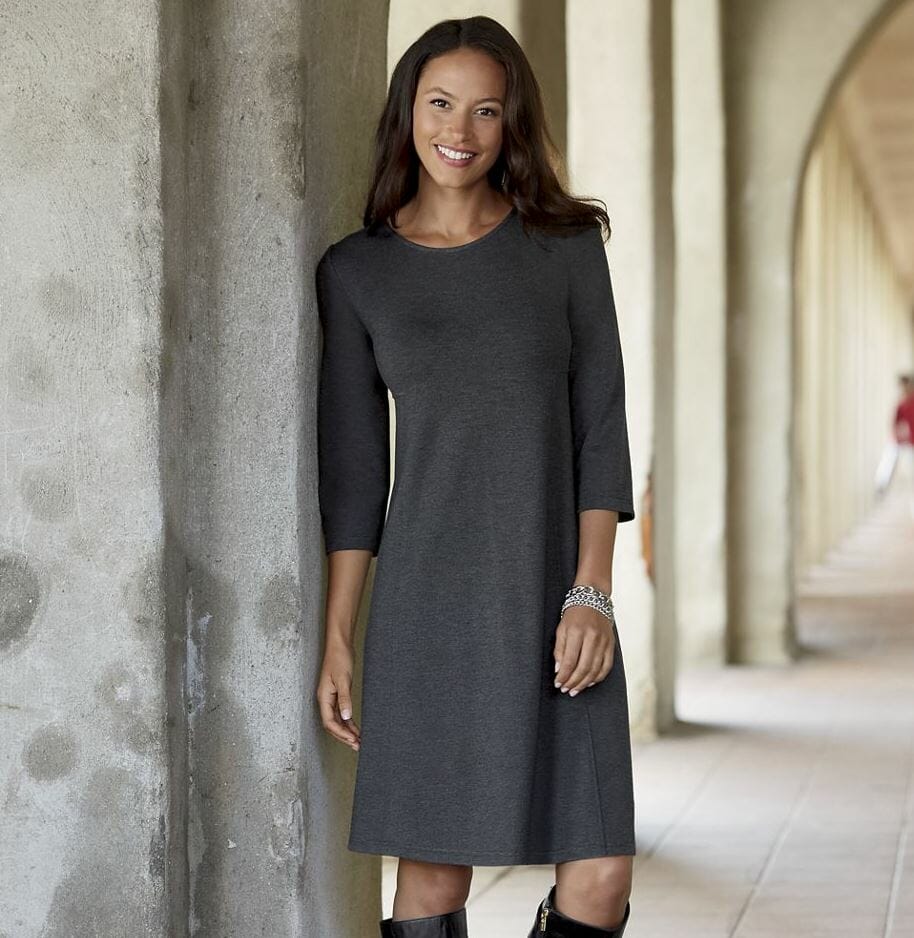 Woman in black tall boots and gray dress