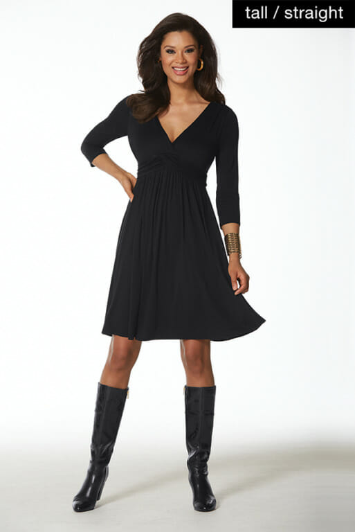 Woman in black elastic waisted dress with tall black boots