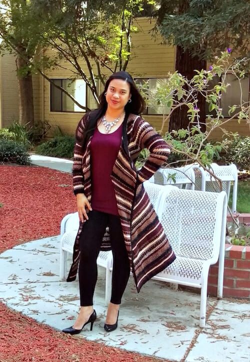 woman wearing long multi-colored sweater and merlot top