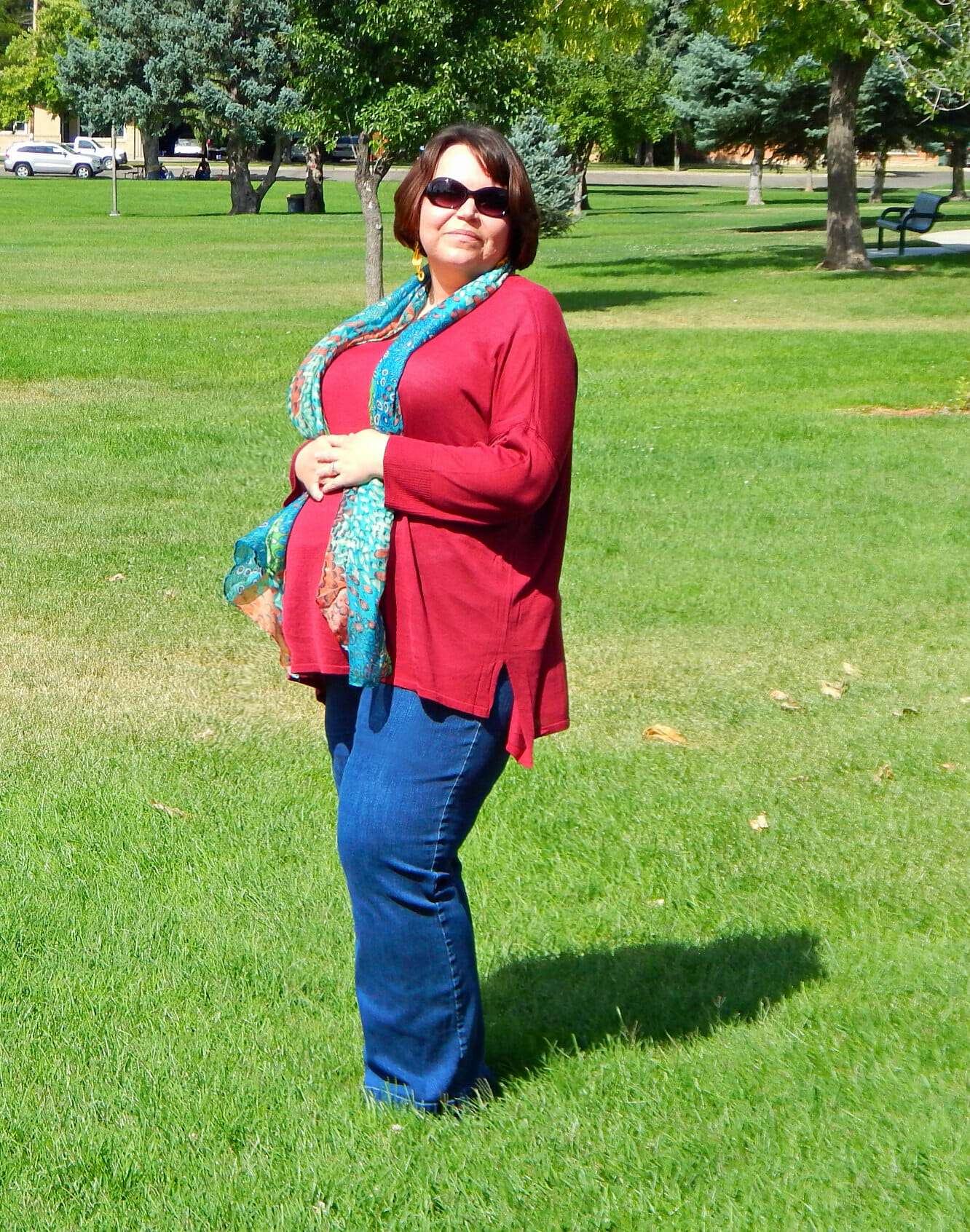 woman wearing a merlot colored top and a leopard print scarf and jeans