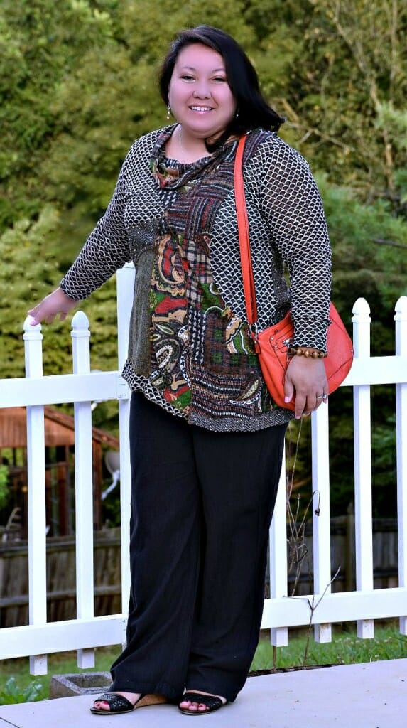 woman wearing a multicolored top with orange accents and an orange handbag