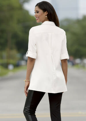 woman wearing a white button-down tunic and black pants