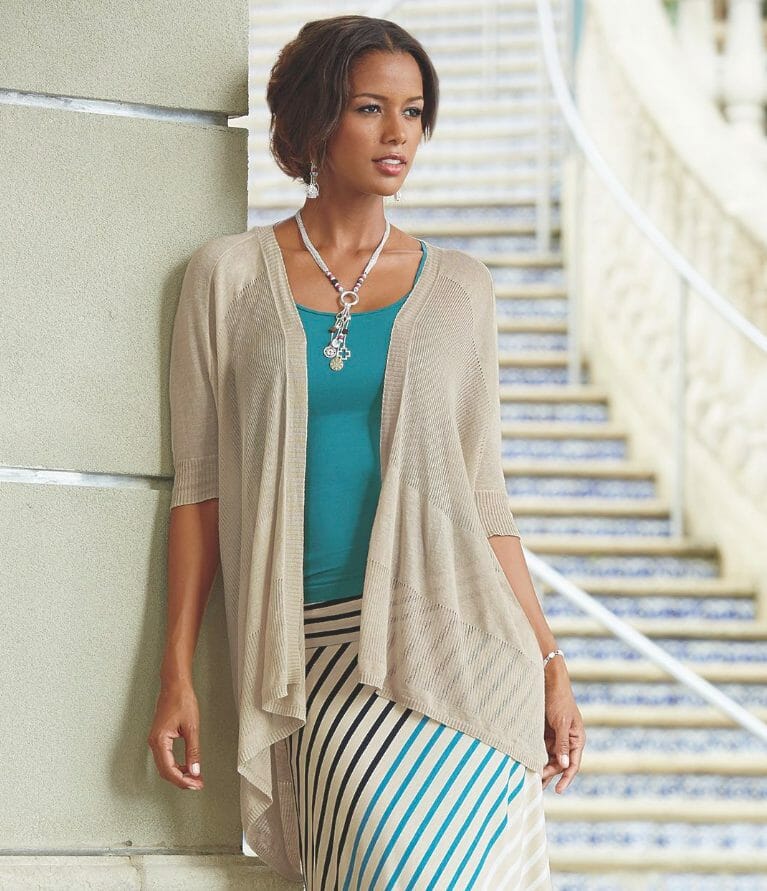 woman wearing creme cardigan over aqua top and multi-stripe skirt
