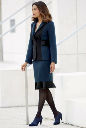Woman in black and blue 2-piece skirt suit and blue shoes