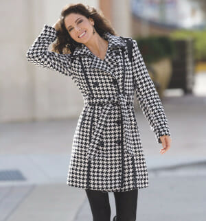 Woman wearing a houndstooth trench coat and black pants