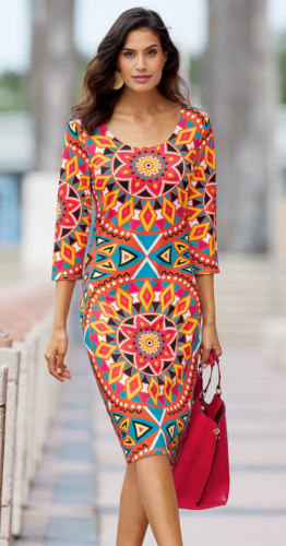 woman wearing a vibrant print patterned knee length dress and carrying red purse