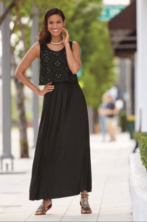 Woman in black eyelit maxi dress with overlay blouse