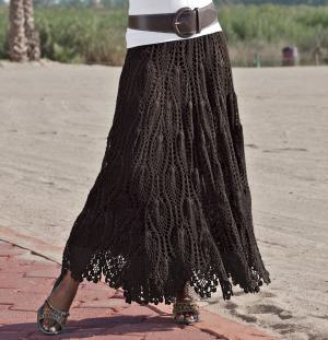 Woman in brown crochet skirt and wide brown belt over white top