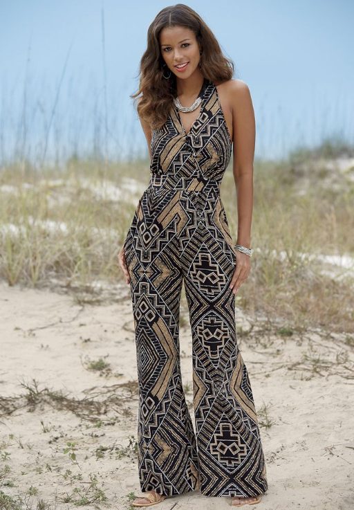Woman in black and gold ethnic-print jumpsuit and gold sandals