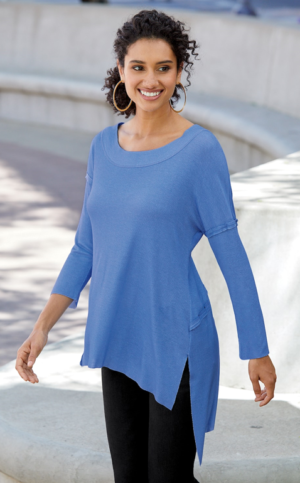 woman wearing black slacks with a light blue, high-low hem, rib knit tunic