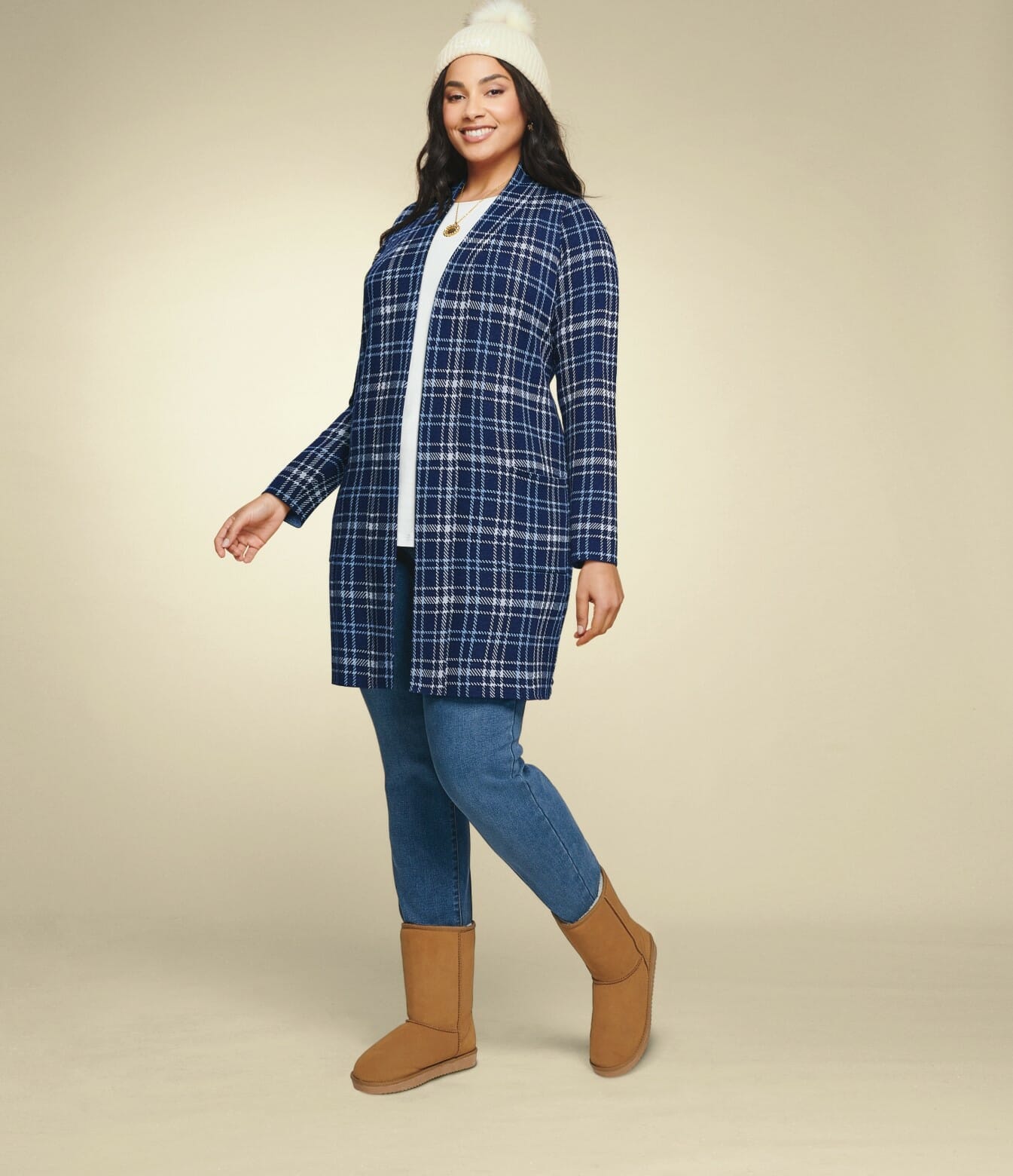 plus-size model wearing a plaid cardigan, jeans, and boots