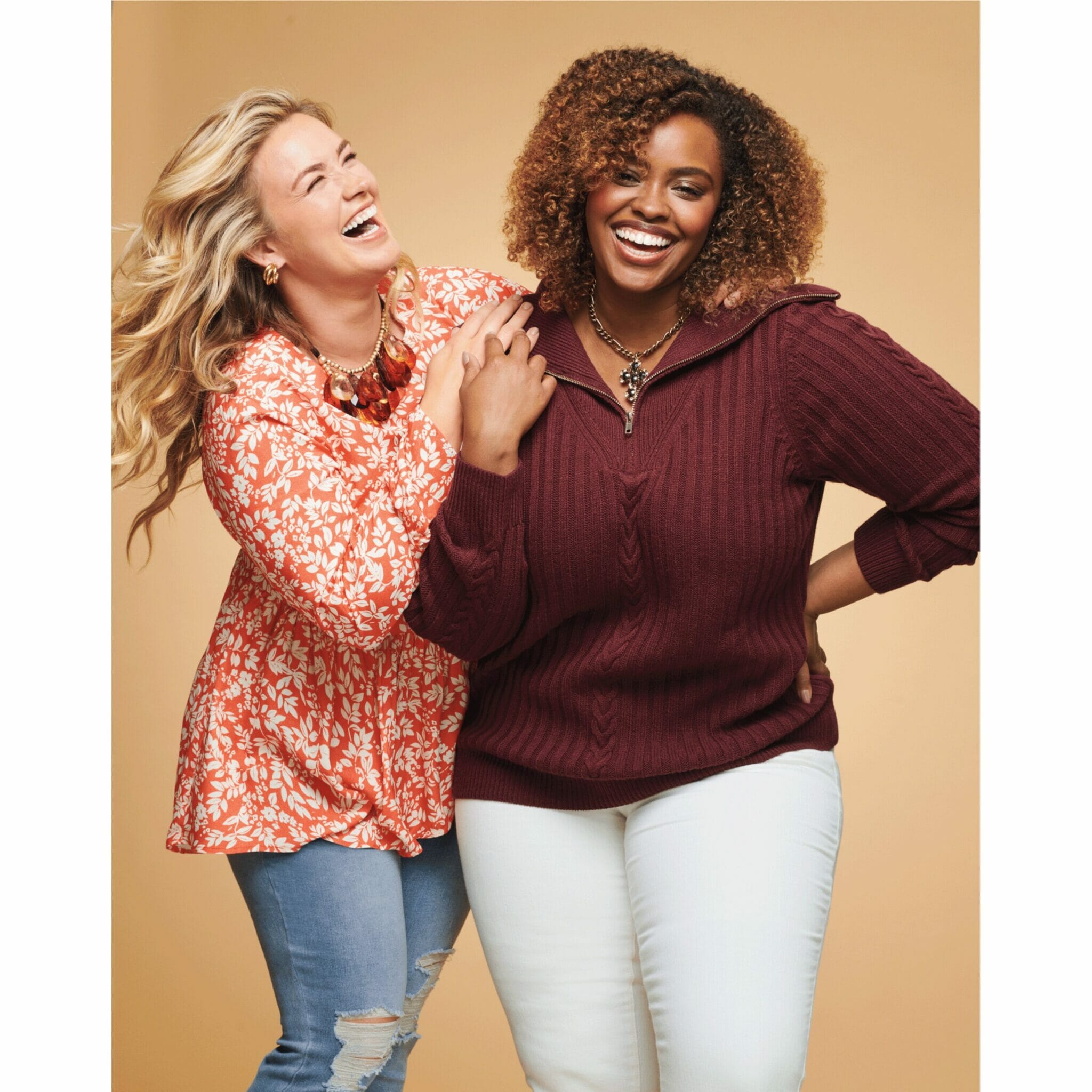 Two plus size models laughing.