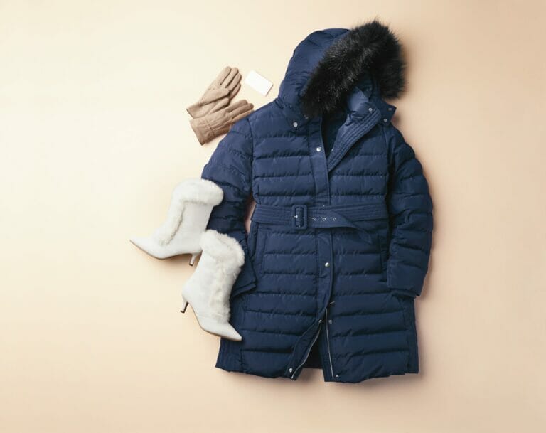 Navy parka with white fur boots and tan gloves.