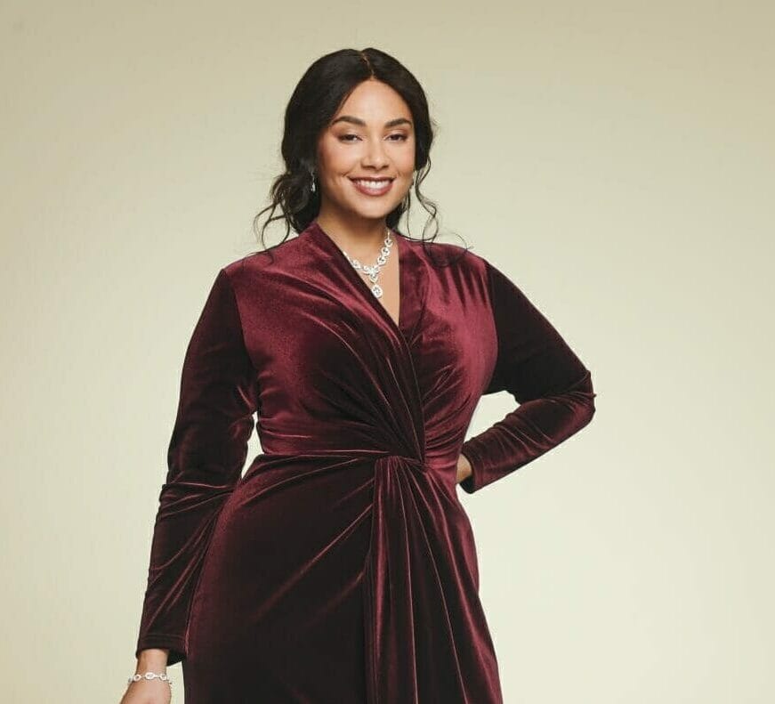 plus size model wearing a burgundy velvet dress with empire waist.