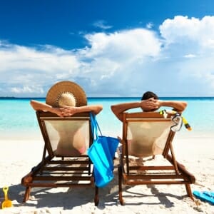 2 people in beach chairs looking at ocean